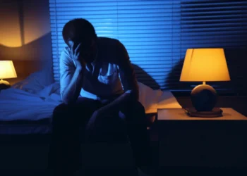 Man sitting on edge of bed at 3am unable to sleep